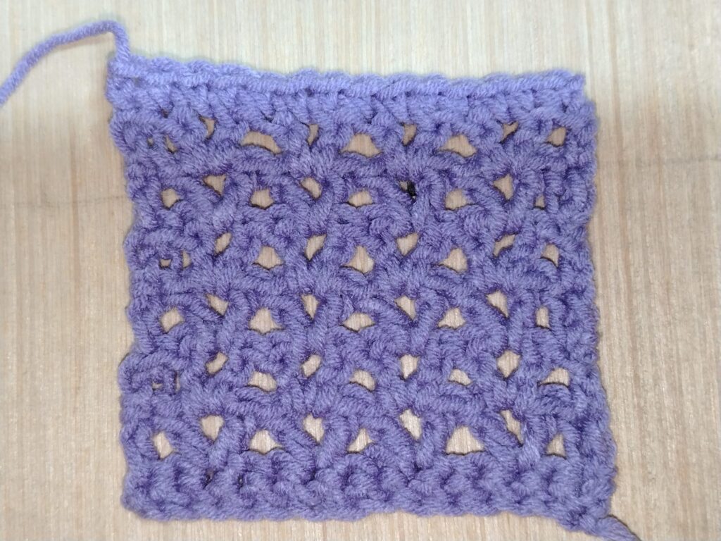 Crochet V-stitch swatch showing an open V-shaped stitch pattern